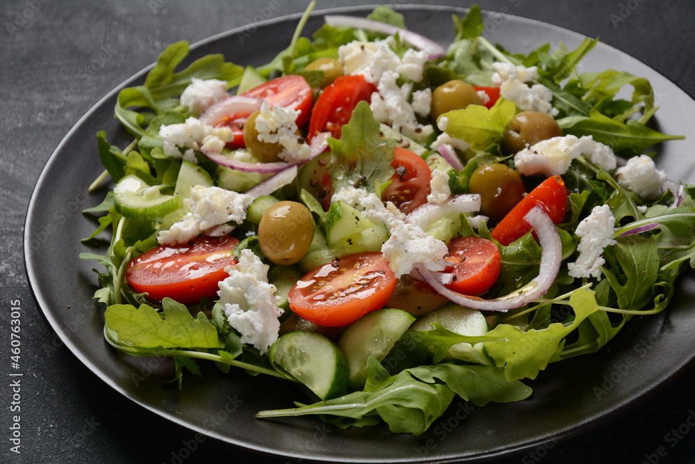 Greek salad of fresh cucumber, tomato, lettuce, red onion, feta cheese and olives with olive oil.