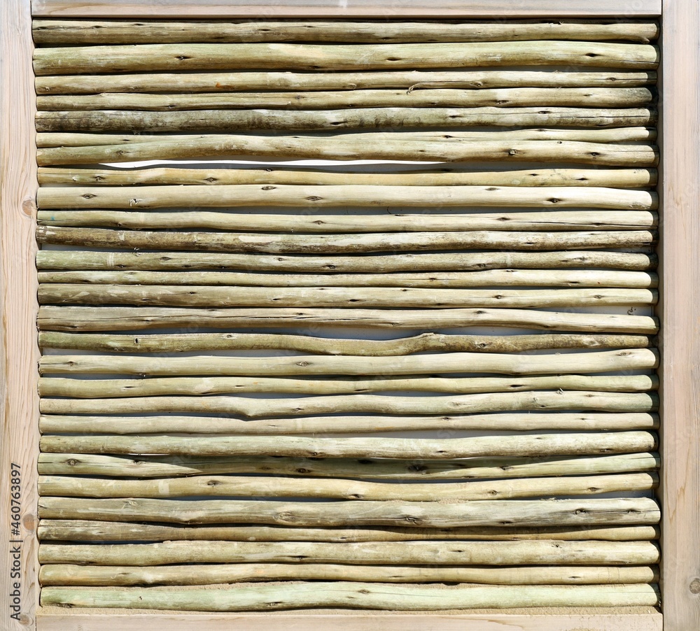 Wooden panel with horizontal barkless branches inside a frame of wooden slats. Background and texture Wooden panel with horizontal barkless branches inside a frame of wooden slats. Background and texture