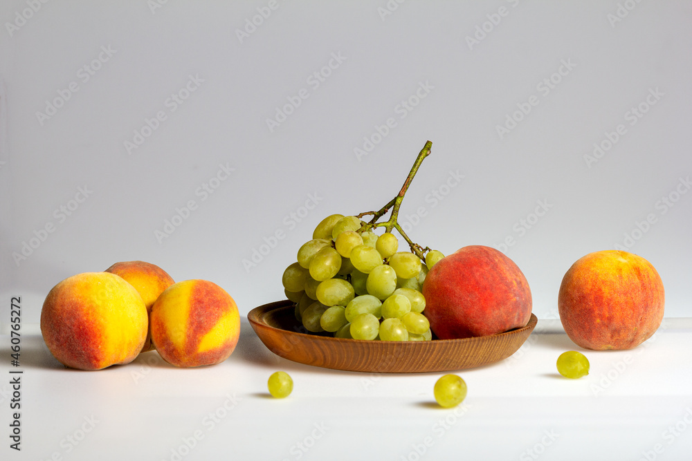 Fruits-grapes, peach, dogwood berries on a milky white background and gray background, close-up. Fruits-grapes, peach, dogwood berries on a milky white background and gray background, close-up.