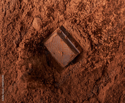 Chocolate piece falling in cocoa powder closeup explosion