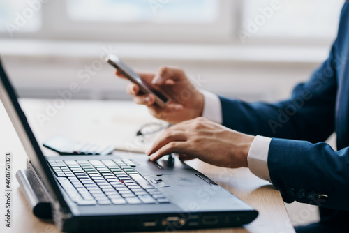 man in a suit working in front of laptop technologies success