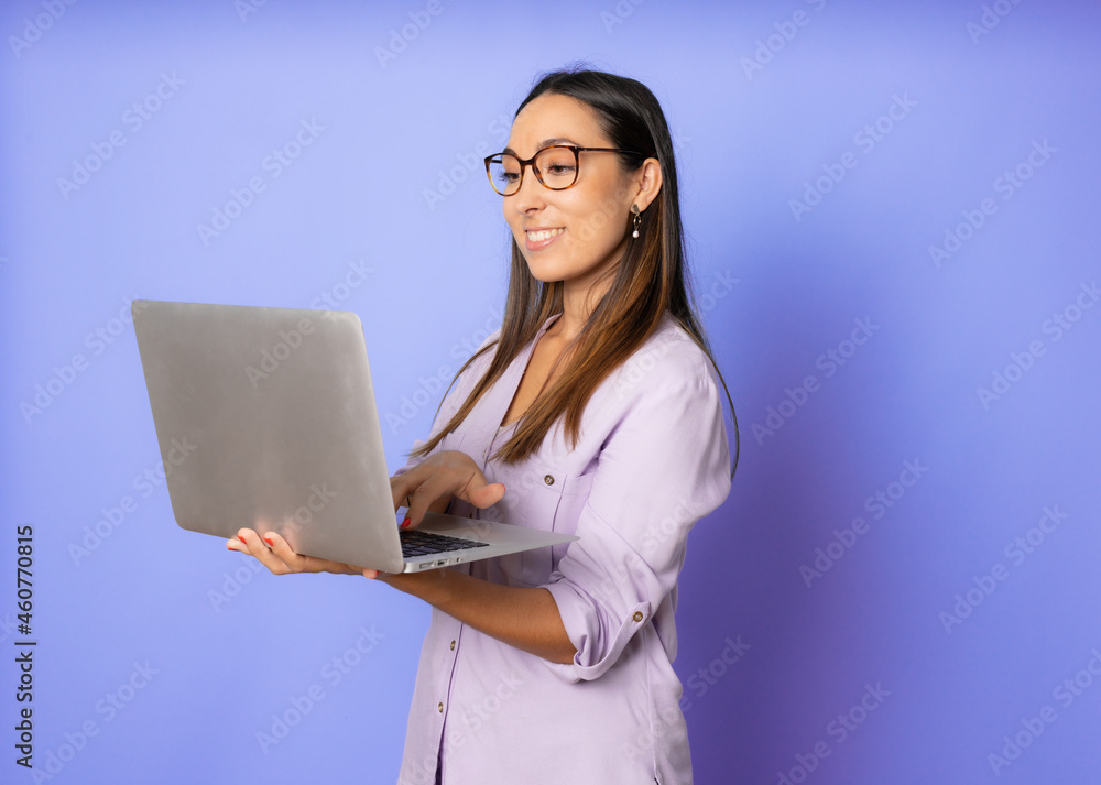 Portrait of a happy young woman using laptop computer isolated over purple background Portrait of a happy young woman using laptop computer isolated over purple background
