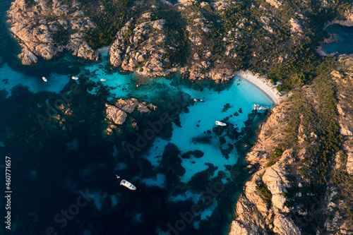 View from above, stunning aerial view of Mortorio island with a beautiful white sand beach and some boats and yachts floating on a turquoise, crystal clear water. Sardinia, Italy.