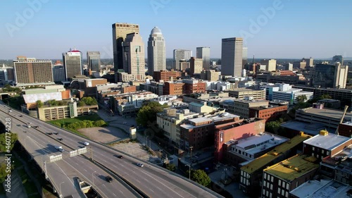 Aerial push in through traffic to louisville skyline
