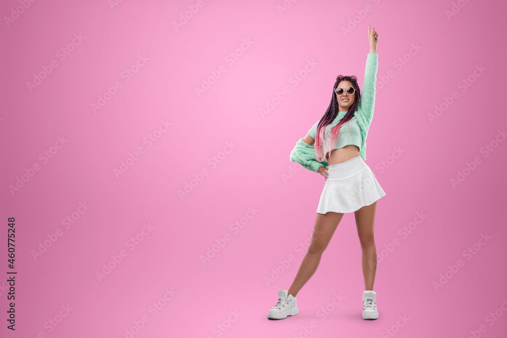 Millennial girl with pink braids hairstyle in turquoise clothes and sunglasses posing on a pink background. Concept for modern style, inclusiveness, individuality, generation Z, copy space. Millennial girl with pink braids hairstyle in turquoise clothes and sunglasses posing on a pink background. Concept for modern style, inclusiveness, individuality, generation Z, copy space.