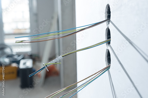 Drähte für Elektroinstallation ragen aus der Wand in Neubau Gebäude