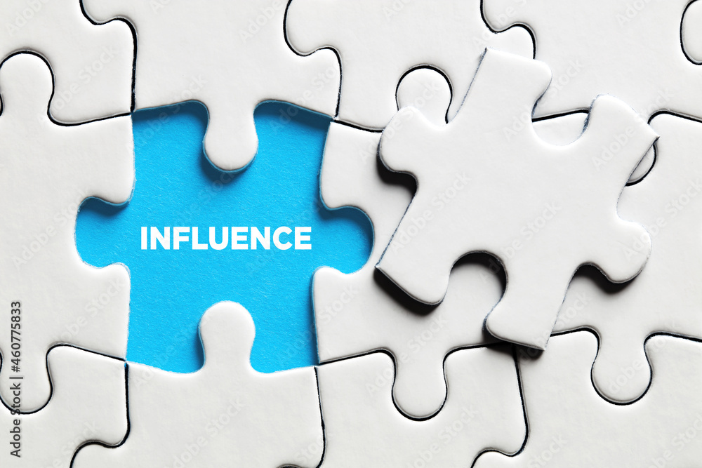 Fototapeta premium The word influence on a missing puzzle piece.