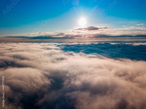 High flight over the fog in the mountains. Ukrainian Carpathians in the morning. Aerial drone view.