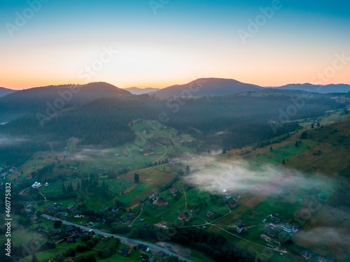 Fog in the mountain valley at dawn. Ukrainian Carpathians in the morning in the haze. Aerial drone view.