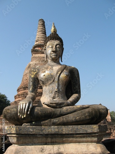 Statue de Bouddha devant un stupa sur le site historique de la ville de Sukothaï en Thaïlande