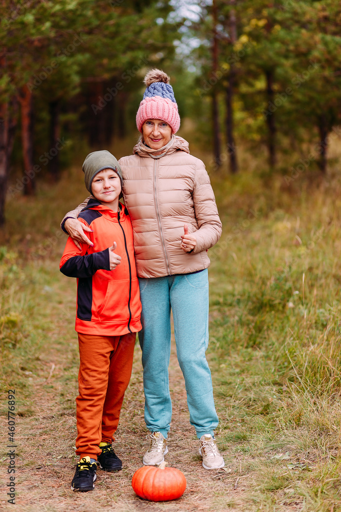 grandmother and grandson take pictures with a pumpkin. harvest. grandmother and grandson take pictures with a pumpkin. harvest.