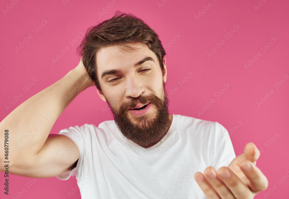 Obraz premium Man in a white t-shirt surprised look pink background