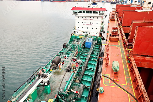 Bunkering operations at the port. Bunker barge alongside of the vessel. Port of Vostochnyy. Russia, December, 2020. photo
