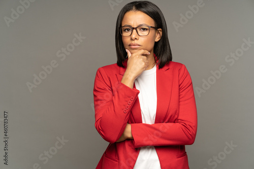 Puzzled thoughtful businesswoman pondering doubtful of business development strategy or partnership contract looking with doubts in camera. Young black entrepreneur female looking for correct decision photo