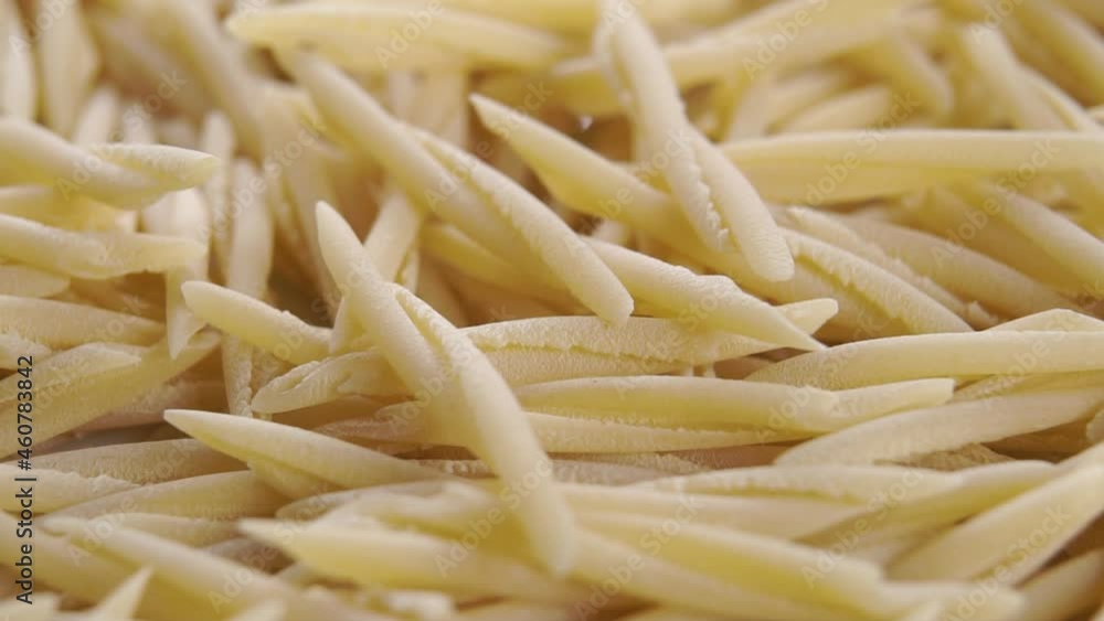 Italian uncooked dry trofie pasta falling in slow motion. Rotation. Macro. Traditional european food concept Italian uncooked dry trofie pasta falling in slow motion. Rotation. Macro. Traditional european food concept