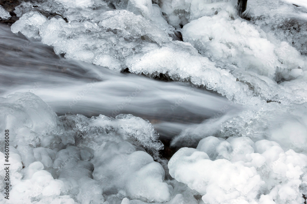 A stream around which ice has formed. The concept of frost, freezing, the beginning of winter, weather forecast.