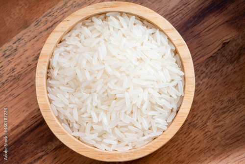 Rice grains in wooden bowl on wooden background, Japanese rice grains in wooden bowl on wooden background.