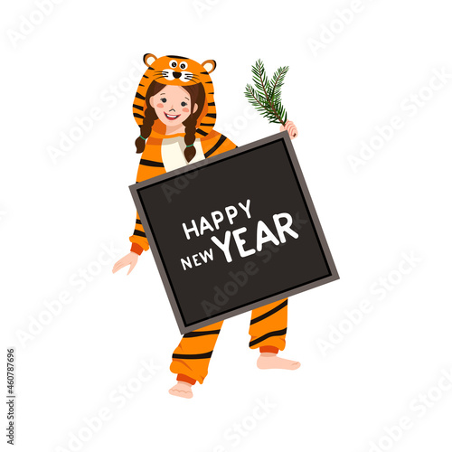 Girl in carnival costume of tiger with sign for text and fir branch in hand. Child in party pyjamas. Kid in jumpsuit or kigurumi, festive clothes for New Year, Christmas or holiday