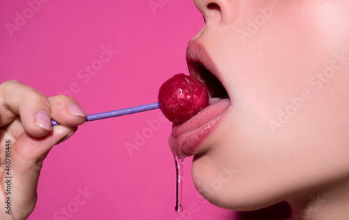 Fotografie Close up, model licking a red lollipop