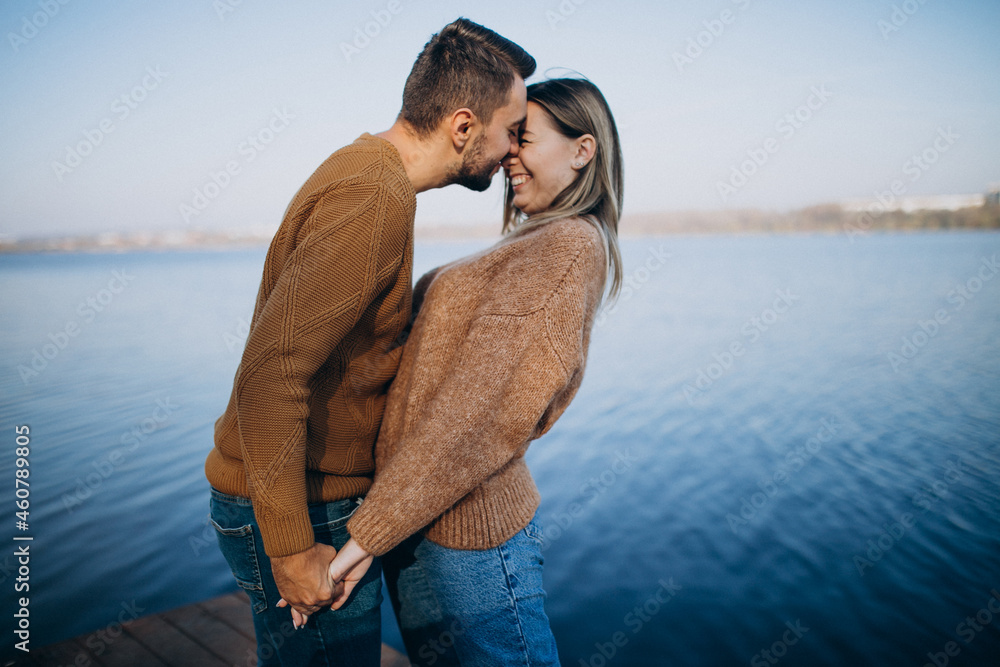 Young couple in park standing by the river