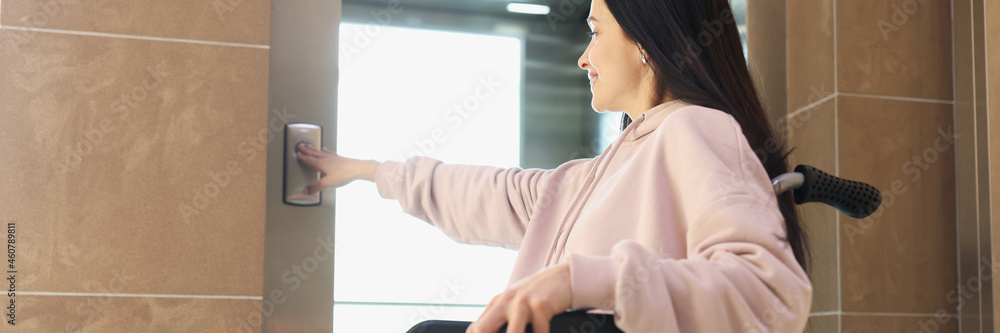 Young smiling woman presses elevator button closeup Young smiling woman presses elevator button closeup