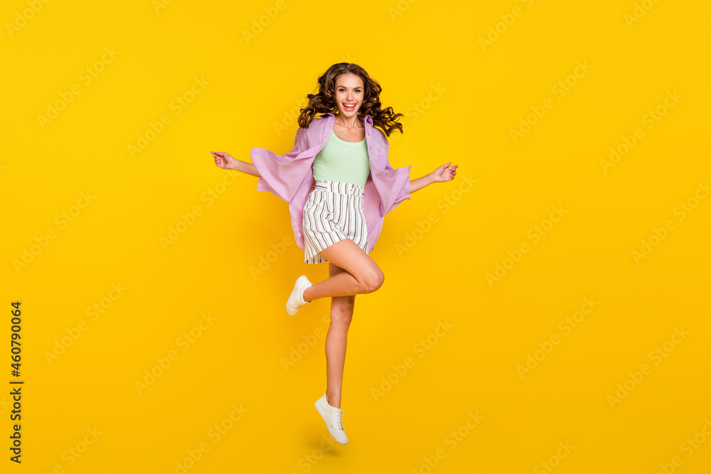 Full length body size photo careless woman jumping high in stylish outfit isolated bright yellow color background