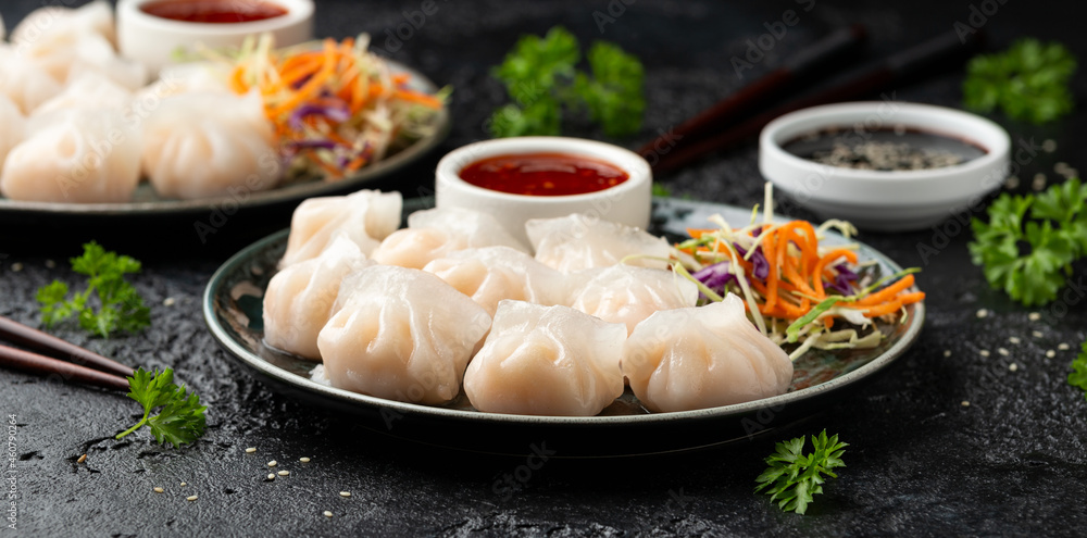 Traditional Asian Prawn or shrimp dumplings hakau, ha kauw or har gow. Served with cabbage, carrot salad and soy and sweet chilli sauce