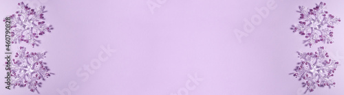 Banner of four transparent snowflakes with golden glitters at the tips on a purple background on the left and right side. Christmas concept lat lay top view with copy space