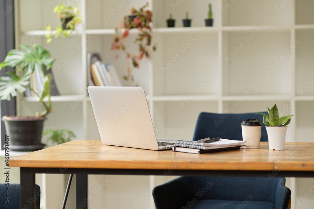 Workplace with a wooden desk, laptop computer, and supplies Workplace with a wooden desk, laptop computer, and supplies