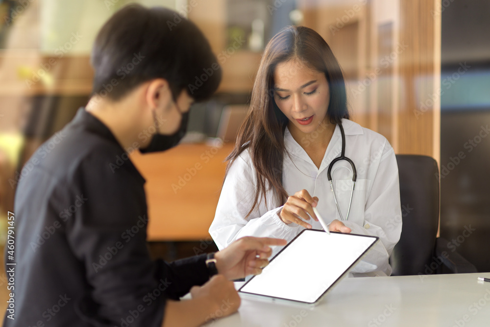 Fototapeta premium Doctor talking with male patient, discussing medical treatment plans on a tablet