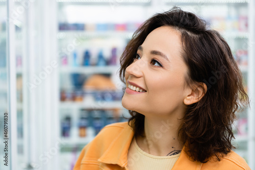 tattooed woman looking away and smiling in drugstore Free Download tattooed woman looking away and smiling in drugstore - GFXLoad