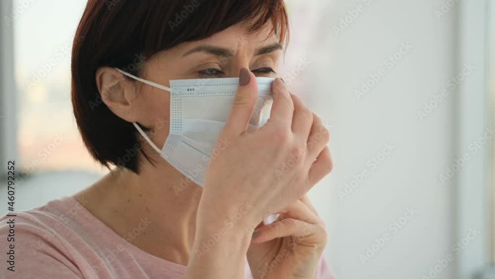 Woman wearing medical mask in hospital during pandemic time. Closeup