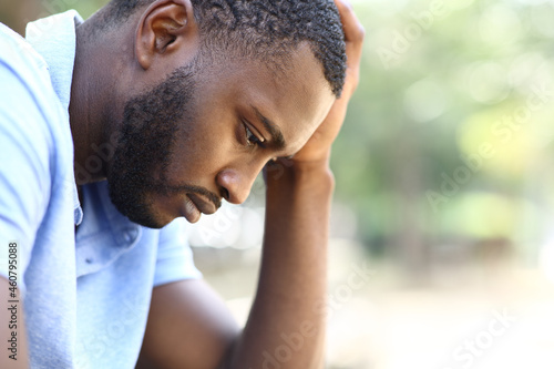 Foto Worried black man complaining alone in a park