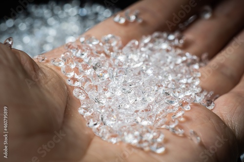 Hand is holding many brilliants or diamond gems. photo