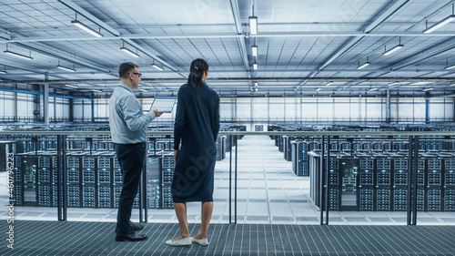 Wallpaper Mural Data Center Female System Administrator and Male IT Specialist Talk, Use Laptop. Information Technology Engineers work on Cyber Security Network Protection in Cloud Computing Server Farm. Torontodigital.ca