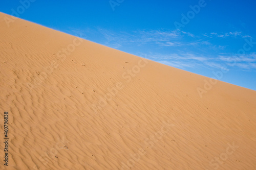 Ripple sand dunes and blue sky background. Desert landscape  sandy waves. Nature.