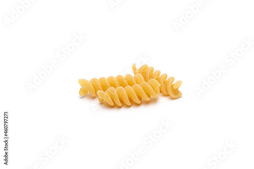 Close up bright yellow uncooked Fusilli pasta on white background.