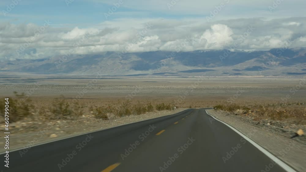 Road trip to Death Valley, driving auto in California, USA. Hitchhiking traveling in America. Highway, mountains and dry desert, arid climate wilderness. Passenger POV from car. Journey to Nevada. Road trip to Death Valley, driving auto in California, USA. Hitchhiking traveling in America. Highway, mountains and dry desert, arid climate wilderness. Passenger POV from car. Journey to Nevada.