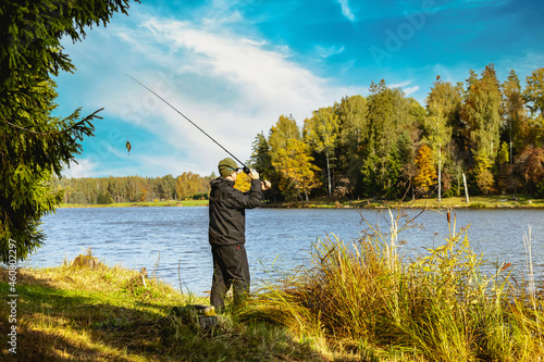 Foto fisherman cast a spinning rod into the lake on sunny day