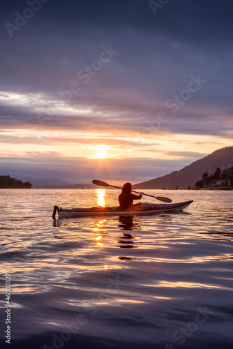 Adventurous Woman on Sea Kayak paddling in the Pacific Ocean. Summer Sunset Sky. Taken near Victoria, Vancouver Islands, British Columbia, Canada. Concept: Sport, Adventure