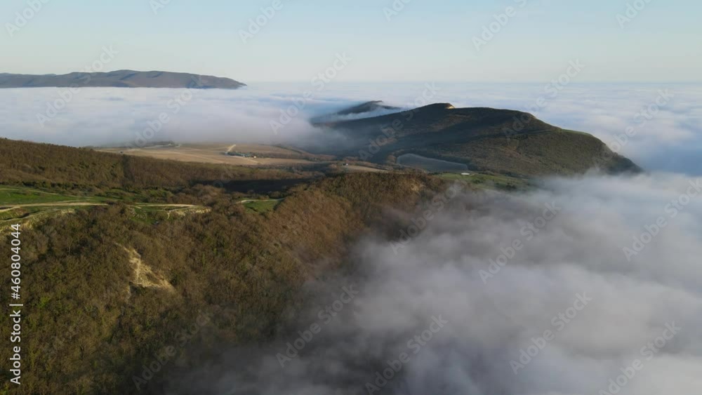 Aerial view of clouds with evening light and mountains. Foggy weather Aerial view of clouds with evening light and mountains. Foggy weather