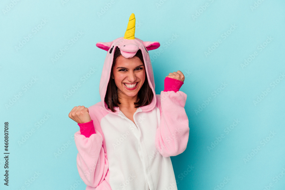 Young caucasian woman wearing an unicorn pajama isolated on blue background Young caucasian woman wearing an unicorn pajama isolated on blue background