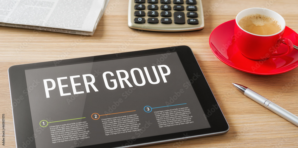 A tablet on a desk with the headline Peer Group A tablet on a desk with the headline Peer Group