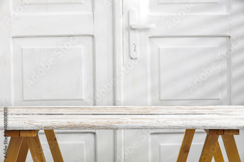 Desk of free space and white wall background with shadows. 