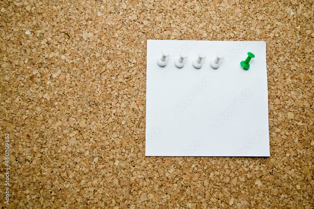 Close-up of cork board with white sticky note. Close-up of cork board with white sticky note.