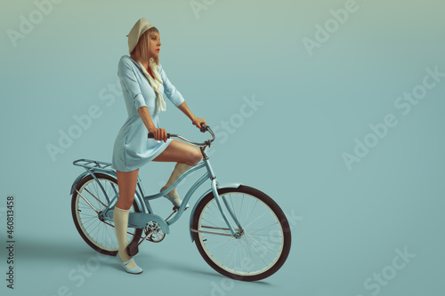 Fototapeta Naklejka Na Ścianę i Meble -  Young blonde woman from the sixties wearing a bob haircut and a beret, standing on her light blue bicycle