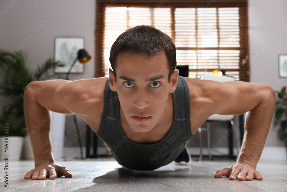 Handsome man doing plank exercise on floor at home Handsome man doing plank exercise on floor at home