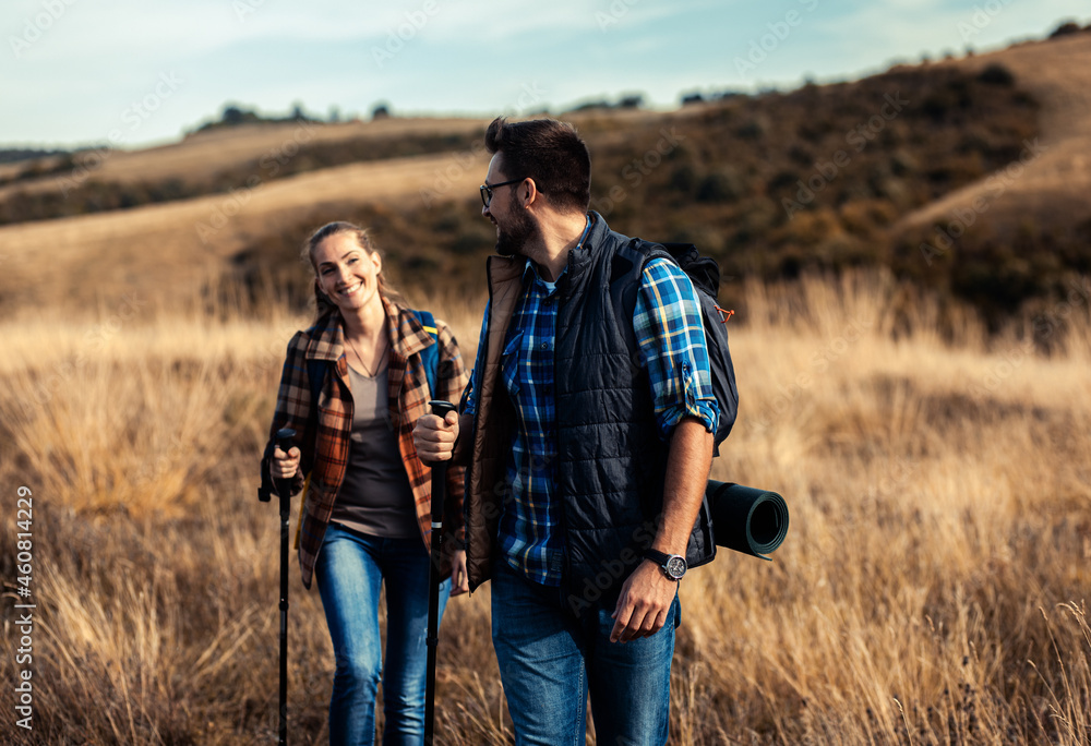 Couple with backpacks hiking together in nature on autumn day. Couple with backpacks hiking together in nature on autumn day.