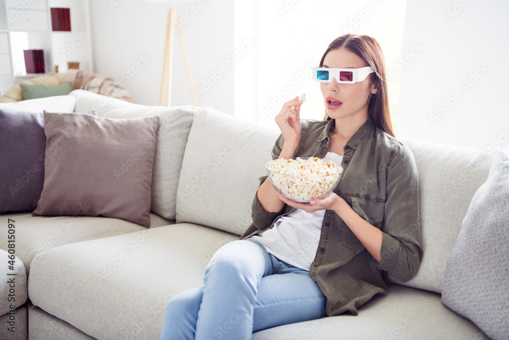 Photo of adorable shocked young woman dressed khaki shirt 3d eyewear eating popcorn watching scary movie indoors home room Photo of adorable shocked young woman dressed khaki shirt 3d eyewear eating popcorn watching scary movie indoors home room