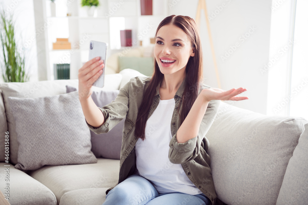 Photo of adorable pretty young lady wear green shirt sitting sofa having video call modern device indoors room home house Photo of adorable pretty young lady wear green shirt sitting sofa having video call modern device indoors room home house